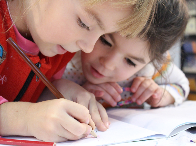 Kinder malen und schauen auf das Blatt